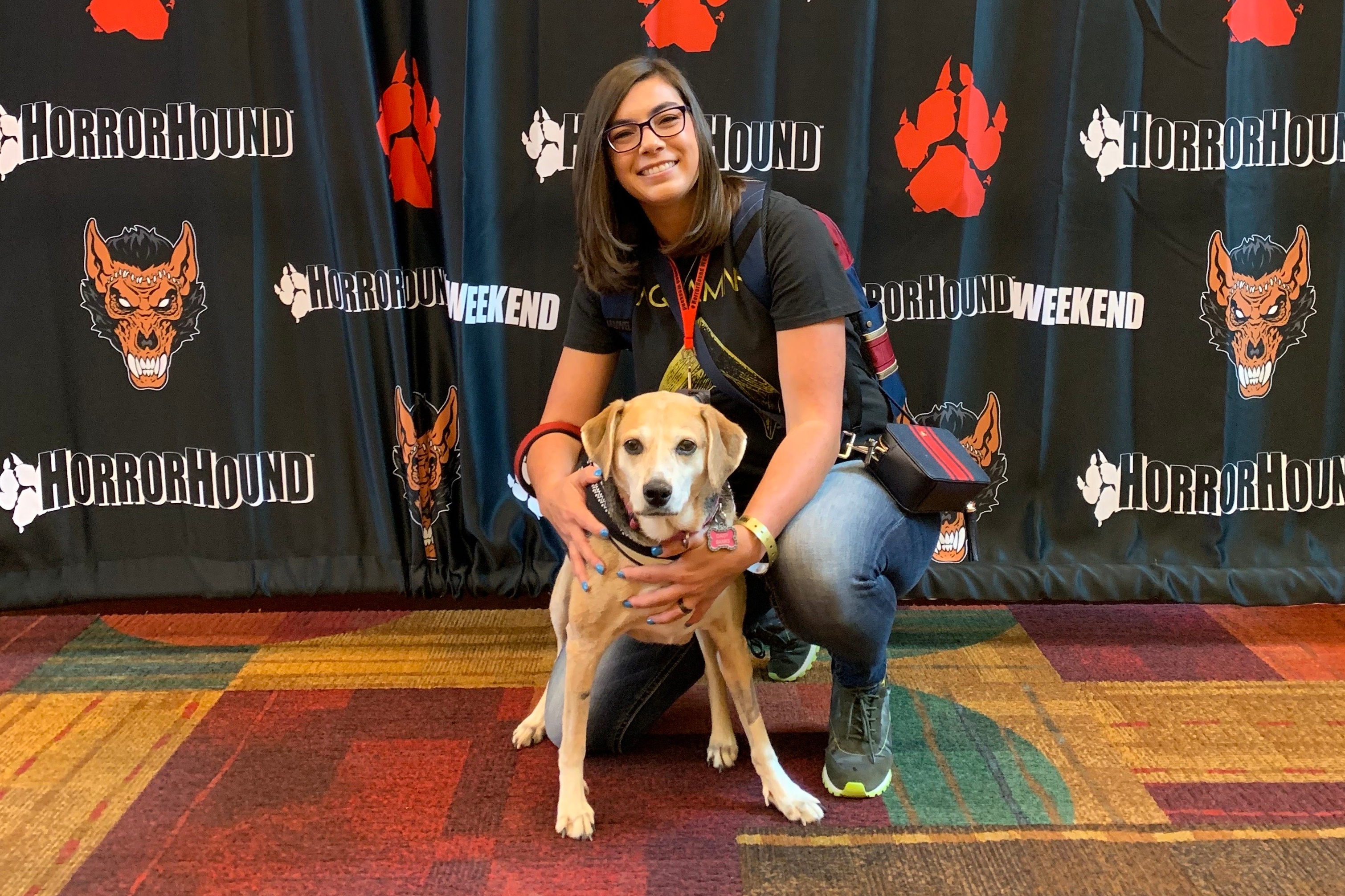 Me and my service dog at a horror film convention. We are posing.